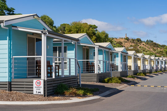 A row of colourful tourist cabins in a caravan park