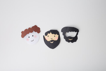 paper cutout resembling hair and beard on a white background. Step in a DIY craft project, possibly...
