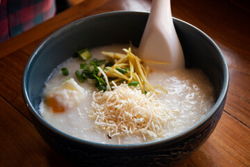 Breakfast traditional chinese food style rice porridge congee with side dish herb vegetable for thai people guest and foreign travelers eating at local dining resort in morning time in Phrae, Thailand
