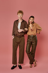 Young couple in stylish attire sharing a moment of love and connection against a vibrant backdrop