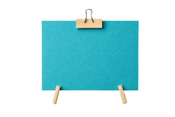 Blue note with wooden clip held by miniature pegs on black background, cut out