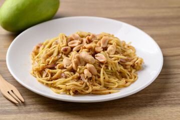 Spicy mango salad on white plate, Thai food