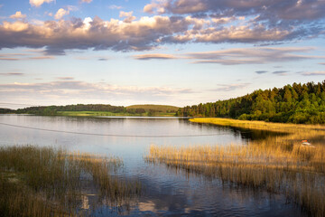 Obraz premium A lake with a cloudy sky in the background