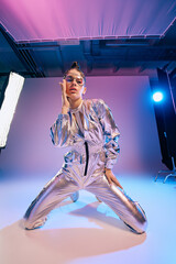 Stylish woman showcases holographic fashion in a vibrant futuristic setting