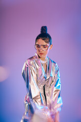 Stylish young woman embraces futuristic fashion with holographic colors under vibrant lighting