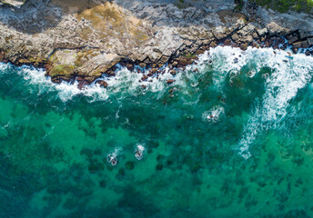 Overhead coastal view of ocean waves crashing onto rocks on the Australian coast