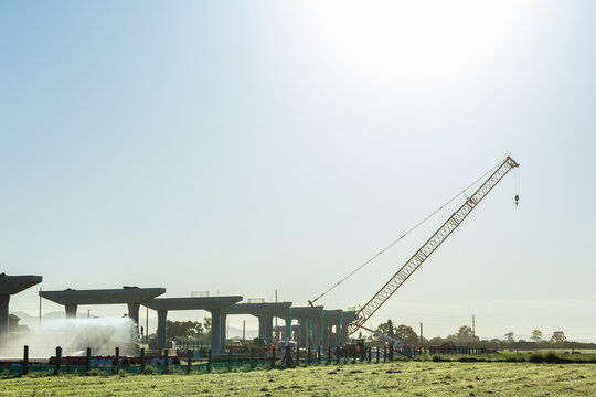 Water spraying truck dampening down ground to minimize dust on construction site