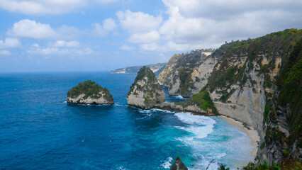 Dramatic coastal cliffs and unique rock formations meet the turquoise ocean in Nusa Penida, Bali. A breathtaking tropical island landscape.