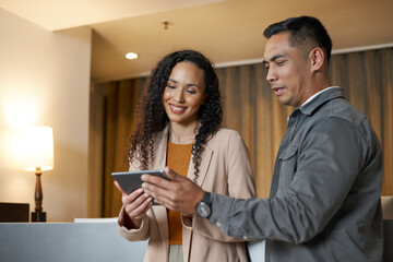 Business Professionals Engaging in a Discussion Using a Tablet in a Modern Hotel Lobby