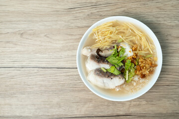 Brown rice and sea bass porridge, Sea bass congee on wooden background.