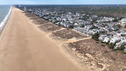 Aerial view of Virginia Beach, VA real estate beach front homes and vacation rentals along the peaceful ocean front coastline with coastal sand dunes
