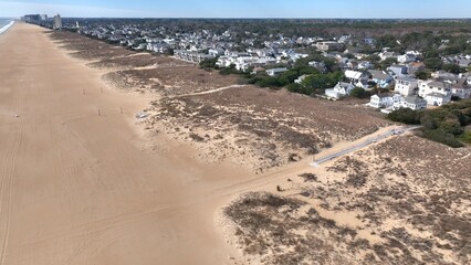 Aerial view of Virginia Beach, VA real estate beach front homes and vacation rentals along the peaceful ocean front coastline with coastal sand dunes