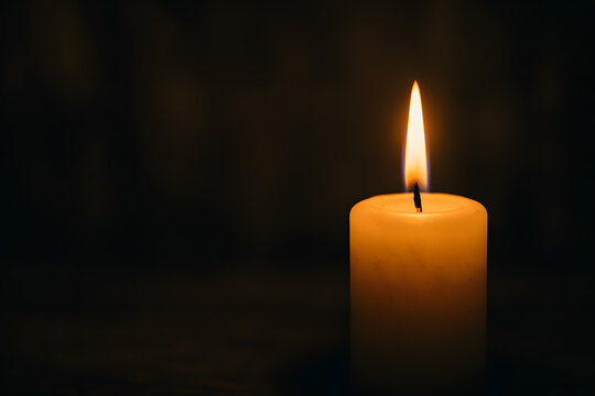 Lit candle in the dark symbolizing prayer, remembrance and spiritual reflection during Lent and Easter