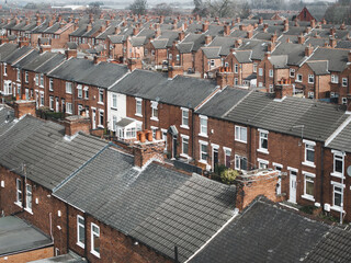 Aerial view above rows of back to back terraced houses on a large council estate