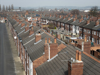 Aerial view above rows of back to back terraced houses on a large council estate