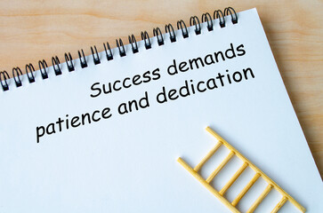 Success demands patience and dedication text on white notepad. Inspirational quote and success...