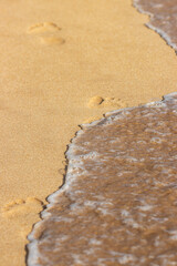 A beach with a wave crashing into the shore