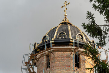 Construction workers are busy completing a religious dome adorned with architectural details. The...