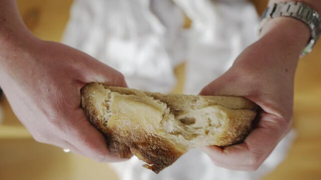 A person is holding a piece of bread that is burnt. The burnt bread has a charred and smoky appearance
