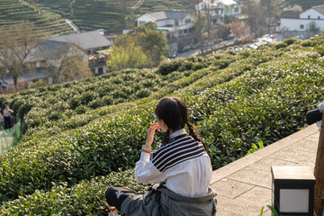 Fototapeta premium Young woman enjoying view of Longjing tea fields in Hangzhou, China