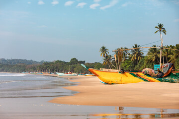 Fishing boats on idyllic sand beach near Tangalla in Sri Lanka.