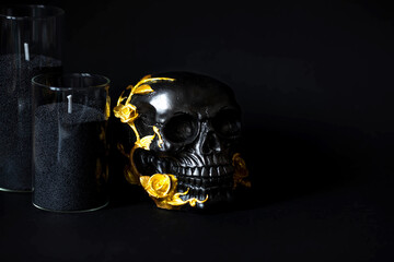 A mysterious black skull with golden roses and pumpkins for a Halloween or Day of the dead party on a black grunge background.