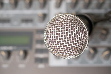 Dynamic microphone against the background of a musical synthesizer. Blurred background. Close-up.