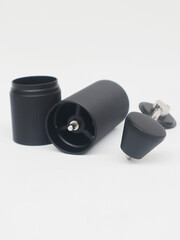 Close-up photo of three main parts of a black manual coffee grinder on a white background