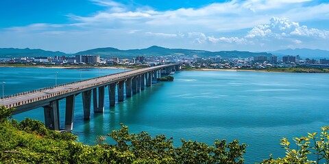 Obraz premium Scenic bridge stretching across turquoise water, cityscape backdrop