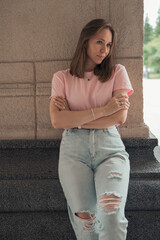 Casual Young Woman Leaning Against Stone Wall
