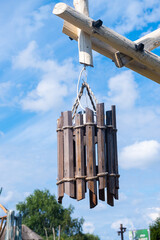 Hanging street lamp with a lampshade made of wooden slats in a city park.