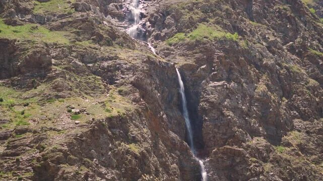 Waterfall in the Himalayan mountain ranges as seen from Tandi village in Pattan valley at Lahaul and Spiti district, Himachal Pradesh, India. Waterfall due to melting of glacier in summer.