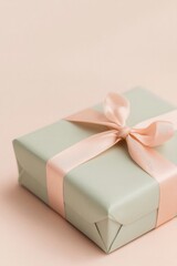 Gift box wrapped in soft mint paper with delicate pink ribbon de