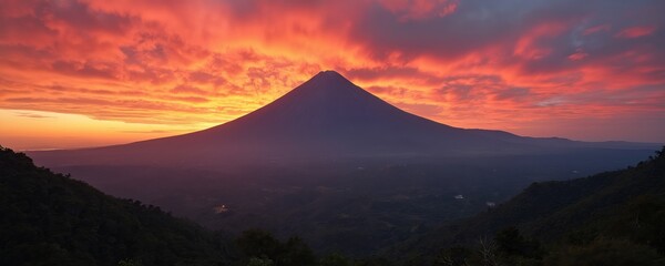 Volcan de Colima at sunset. Majestic volcano silhouette against vibrant sunset sky. Orange, red clouds with soft light. Mountain landscape natural beauty. Mexico nature at twilight.