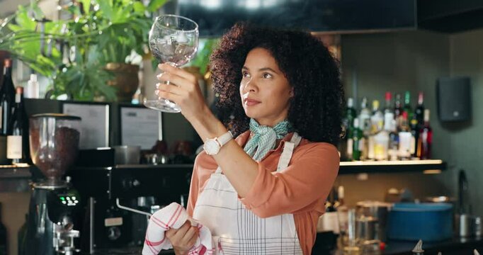 Waitress, woman and cleaning glass in restaurant for hygiene, dust removal and workflow maintenance. Hospitality industry, happy barista and wipe glassware with inspection, germs or bistro sanitation