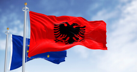 Albanian national flag and European Union flag waving together against sky