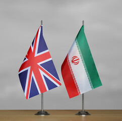 Table flags United Kingdom and Iran on grey blurred background