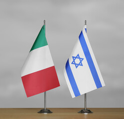 Table flags of Israel and Italy on a gray blurred background