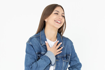 Portrait of extremely happy girl in white t-shirt and jeans coat holding her stomach and chest and laughing out loud, chuckling at amusing anecdote, sincere emotion