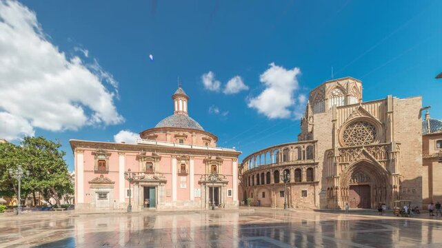 Panoramic timelapse hyperlapse of Valencia's Plaza de la Virgen, showcasing the Cathedral, Basilica de la Virgen de los Desamparados and Turia Fountain in Spain's historic old town under a blue sky
