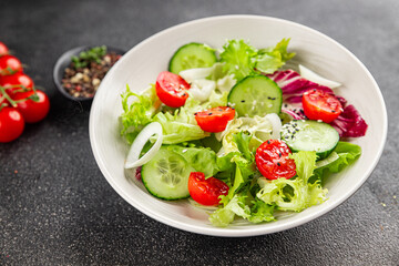 Vegetable salad tomato, cucumber, lettuce, green leaf lettuce, onion appetizer vegetable dish fresh gourmet food background rustic food top view copy space keto and paleo diet vegetarian vegan food