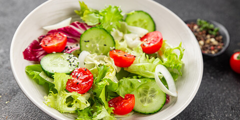 Vegetable salad tomato, cucumber, lettuce, green leaf lettuce, onion appetizer vegetable dish fresh gourmet food background rustic food top view copy space keto and paleo diet vegetarian vegan food