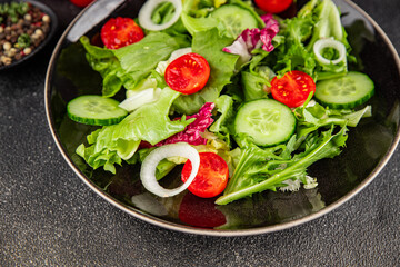 Vegetable salad tomato, cucumber, lettuce, green leaf lettuce, onion appetizer vegetable dish fresh gourmet food background rustic food top view copy space keto and paleo diet vegetarian vegan food