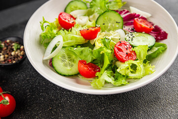 Vegetable salad tomato, cucumber, lettuce, green leaf lettuce, onion appetizer vegetable dish fresh gourmet food background rustic food top view copy space keto and paleo diet vegetarian vegan food