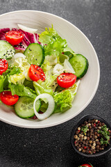 Vegetable salad tomato, cucumber, lettuce, green leaf lettuce, onion appetizer vegetable dish fresh gourmet food background rustic food top view copy space keto and paleo diet vegetarian vegan food