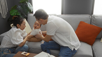 Mother and father playing with baby boy in living room showing family love indoors in comfortable home setting.