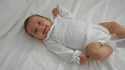 Adorable newborn boy lying on a cozy bed in a home bedroom, showcasing cute childhood innocence and...