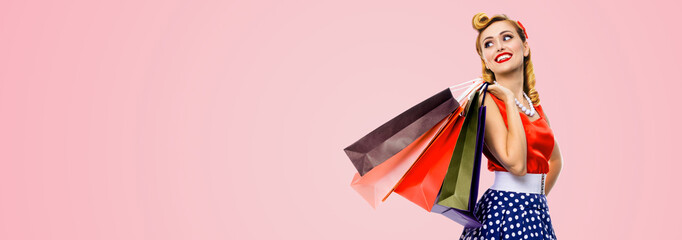 Portrait image - happy smile young cute woman in pinup dress carrying colorful shopping packages...