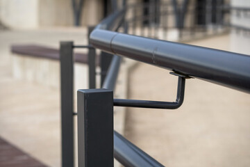 black metal railing with curved tube and rectangular supports.