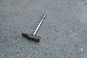 Photo of an iron hammer on the ground